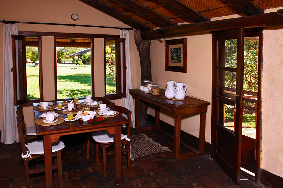 Comedor con mesa de madera y vista al jardín  -  desayuno servido