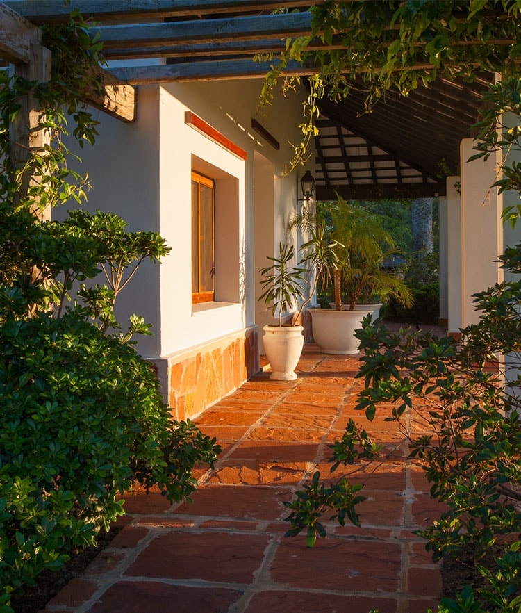 Galería cubierta con baldosas de terracota al atardecer