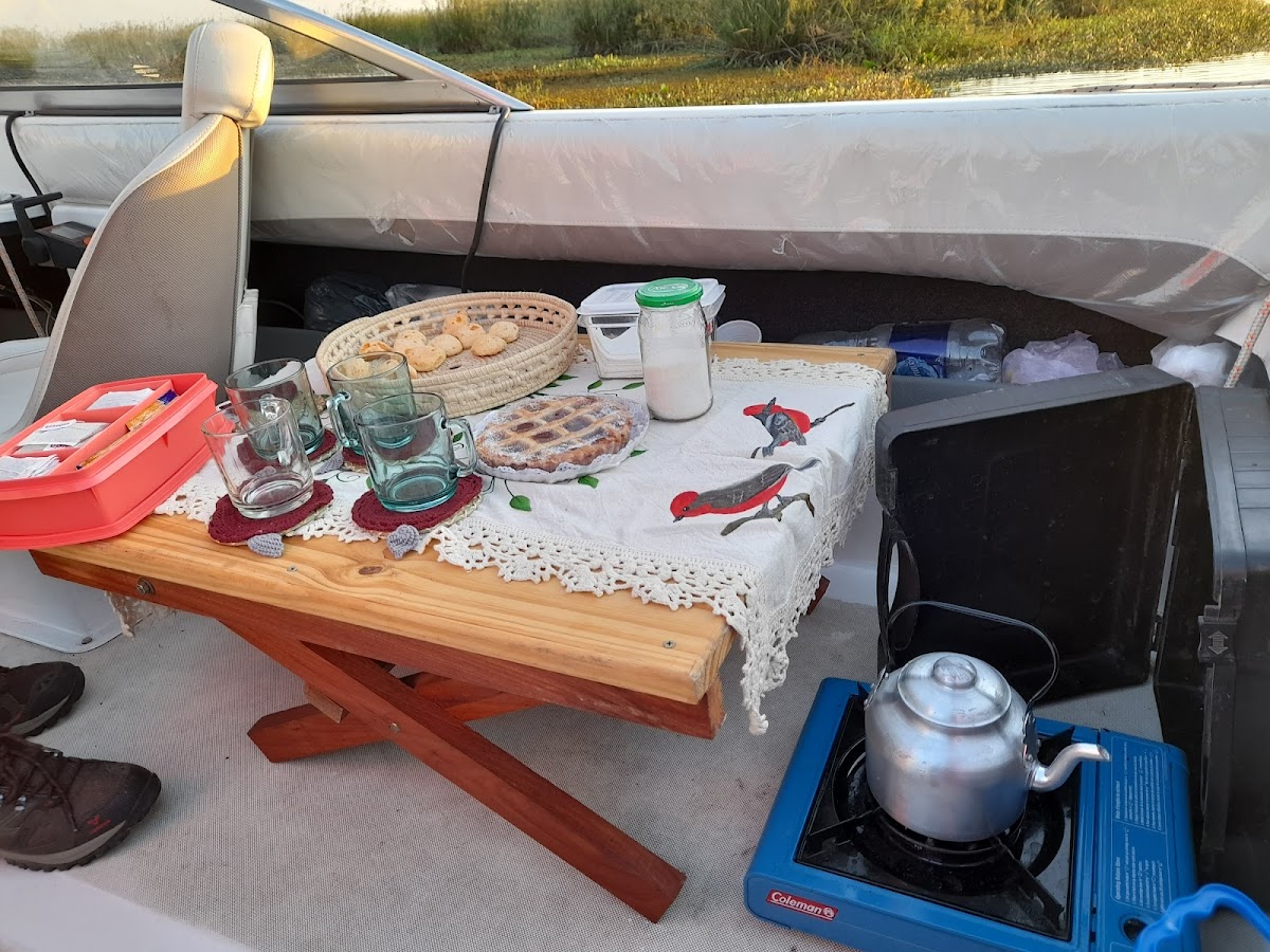 Merienda a bordo: tarta casera, galletitas y pava sobre cocina Coleman