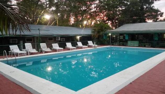 Piscina con reposeras al atardecer en las cabañas Simons