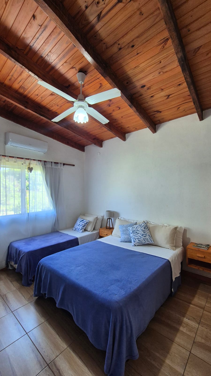 Bedroom with a double bed and a single bed, air conditioning and a ceiling fan