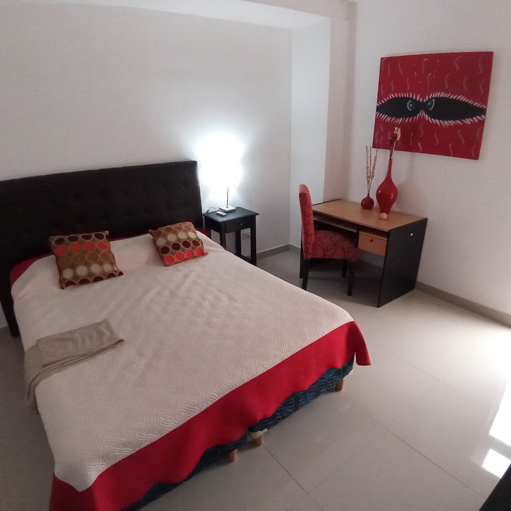 Habitación del Tobuna Suites con cama doble y arte en la pared