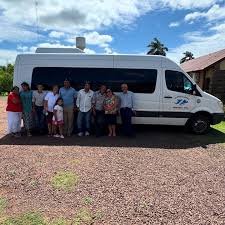 Grupo de pasajeros con el minibus de Transporte 2 de Abril