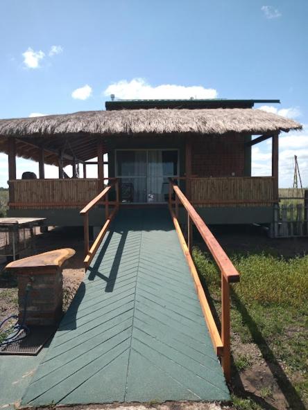 Acceso al lodge con rampa de madera y galería techada