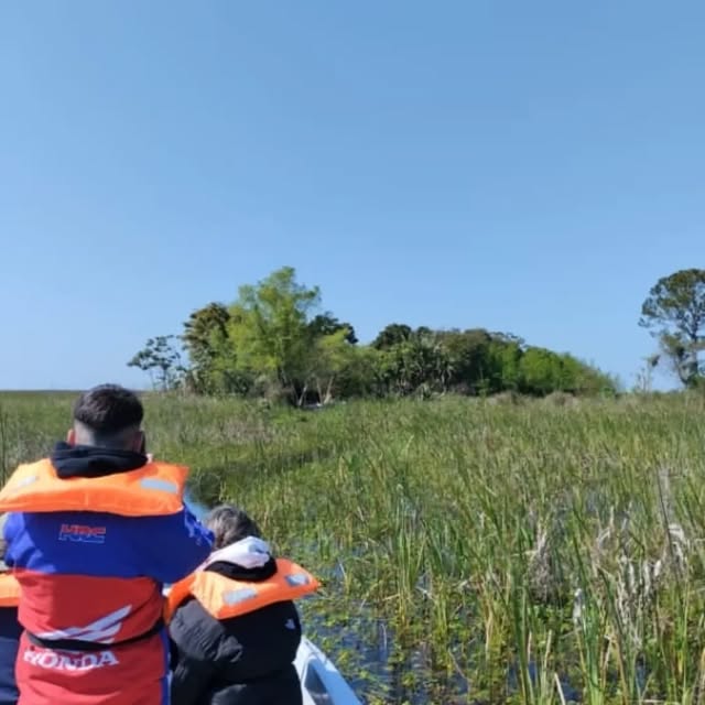 Lancha aproximándose a Isla Disparo en el Portal Carambola con el monte nativo al fondo