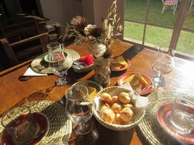 Mesa del comedor con medialunas, copas y flores