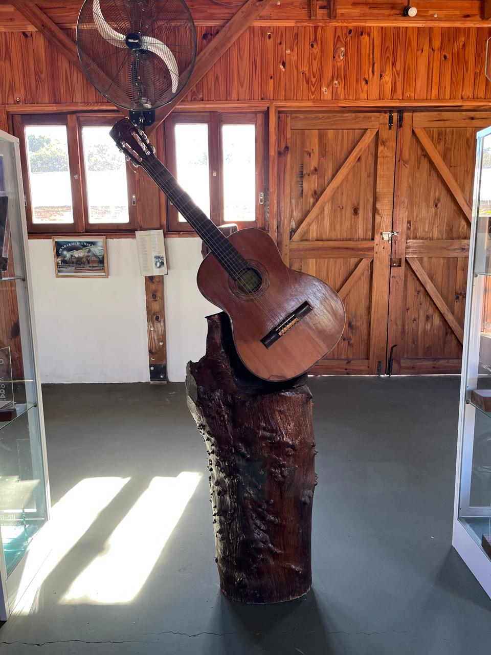 La guitarra del cantautor, montada sobre un tronco de madera nativa